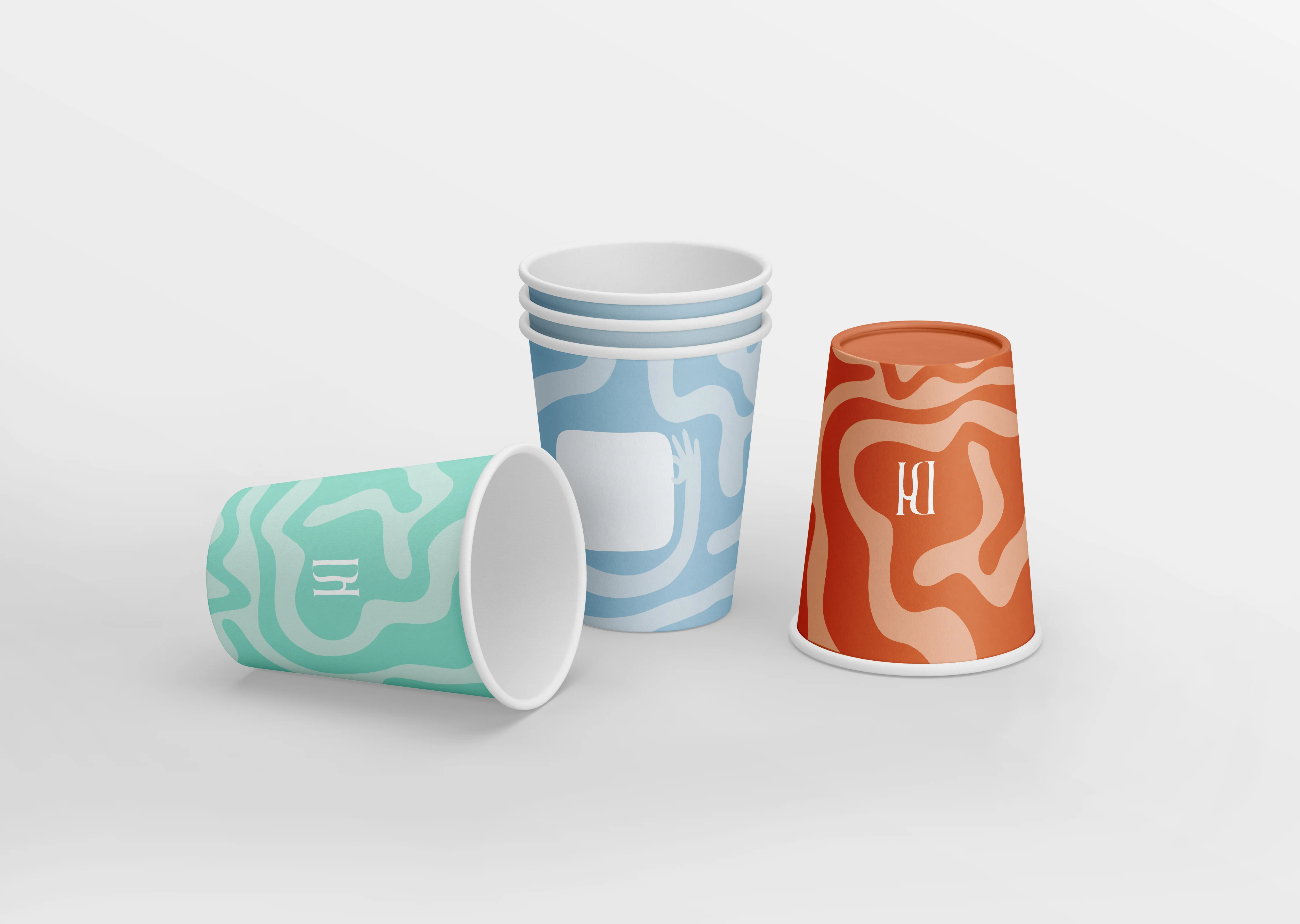 Drip Happens hot cups with the brand pattern in mint, blue and orange